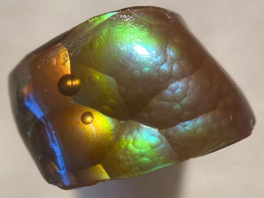 Iridescent Deer Creek fire agate loose gemstone with reflective surface on a neutral background