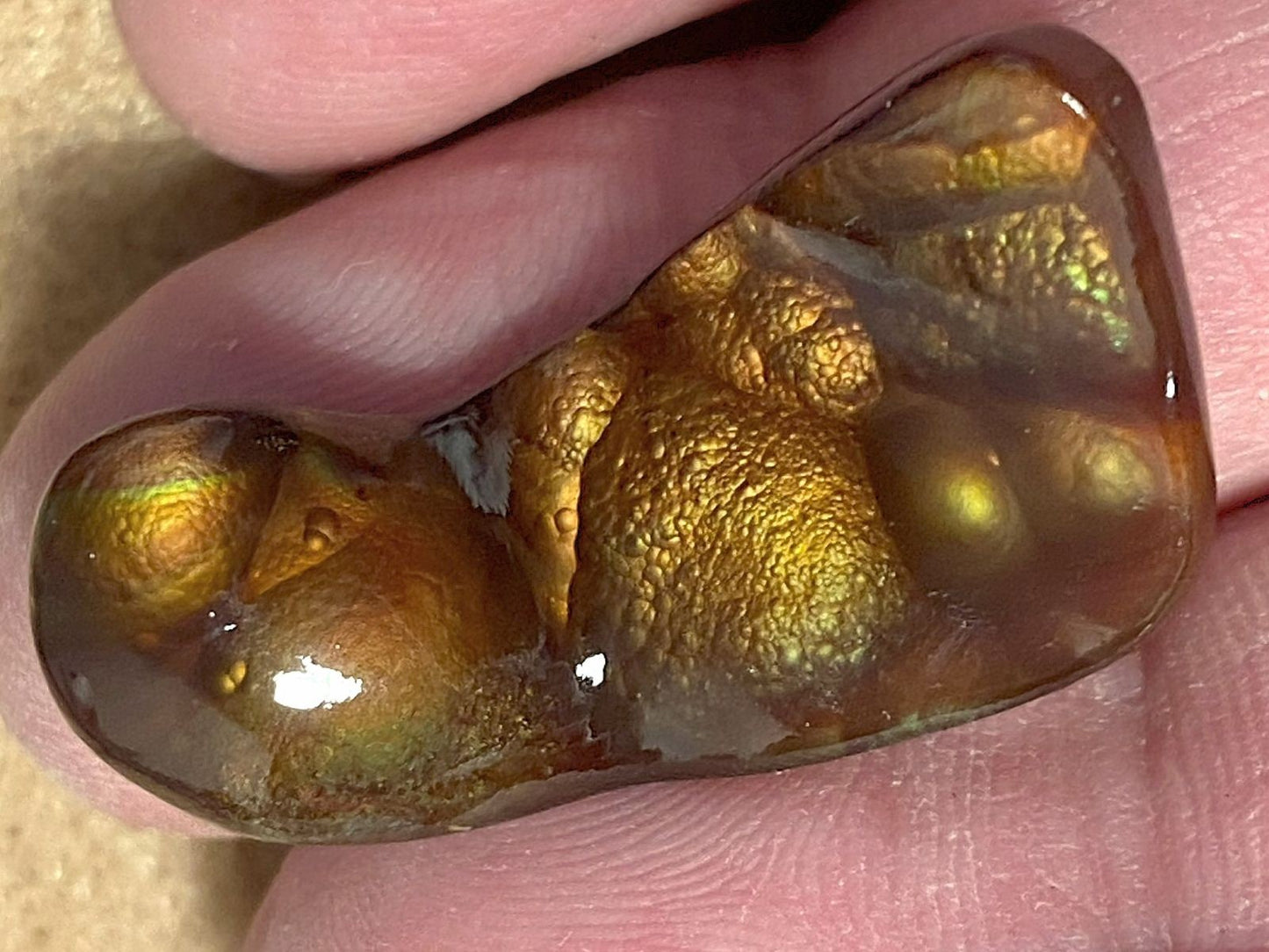 Deer Creek Fire Agate Gemstone held between fingers