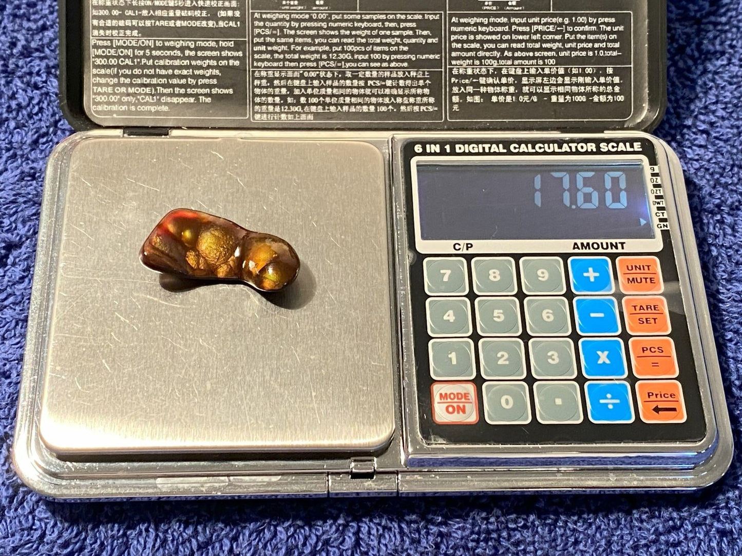 Deer Creek Fire Agate Gemstone on a digital calculator scale with visible weight reading.