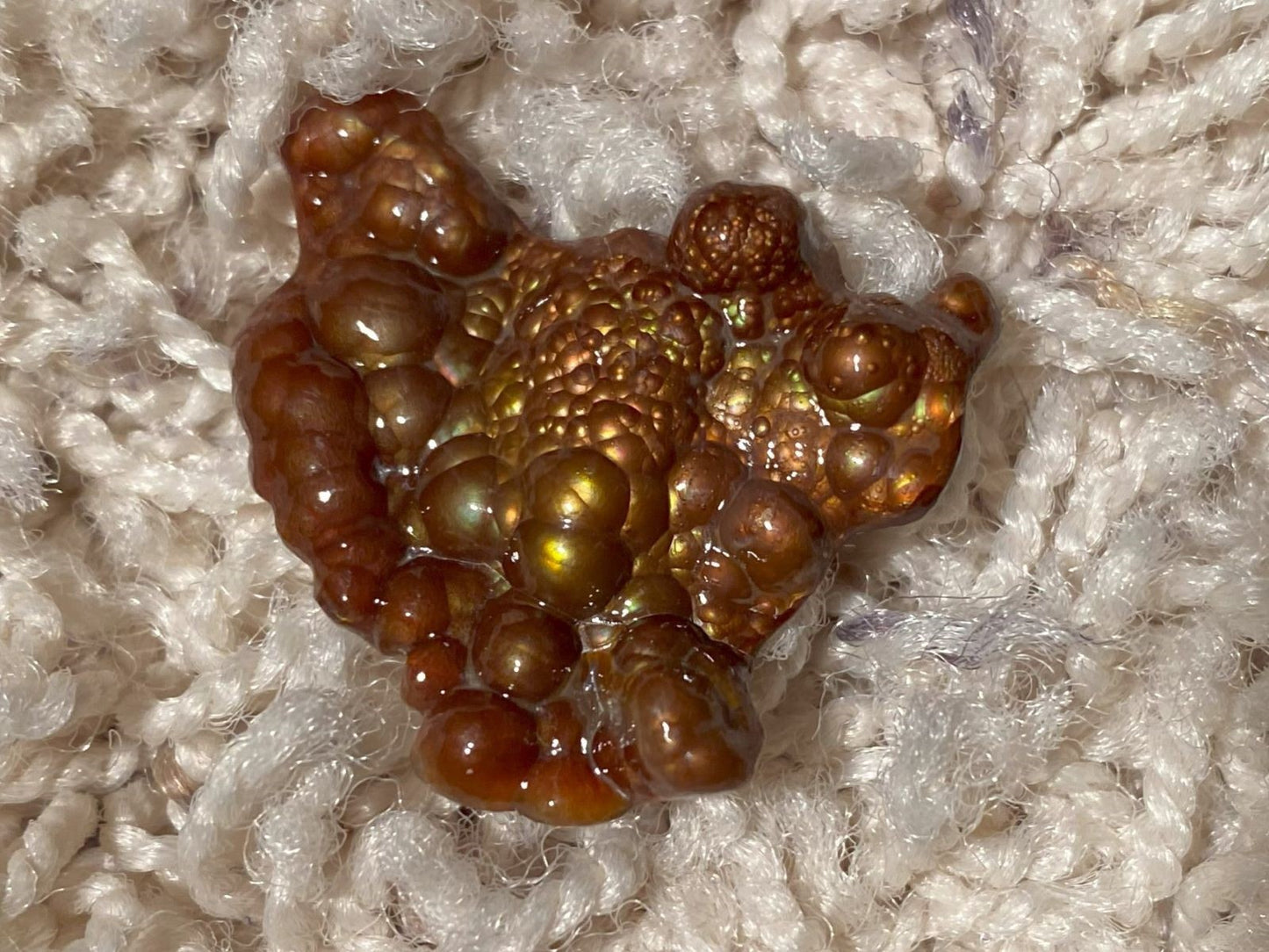 Close-up of a Deer Creek Fire Agate Gemstone Mineral Specimen on a textured white background