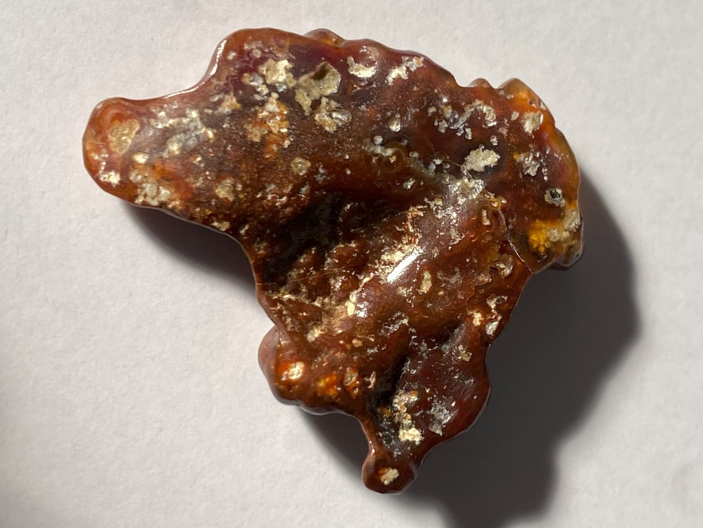 Bottom of Deer Creek Fire Agate Gemstone Mineral Specimen on a light gray background