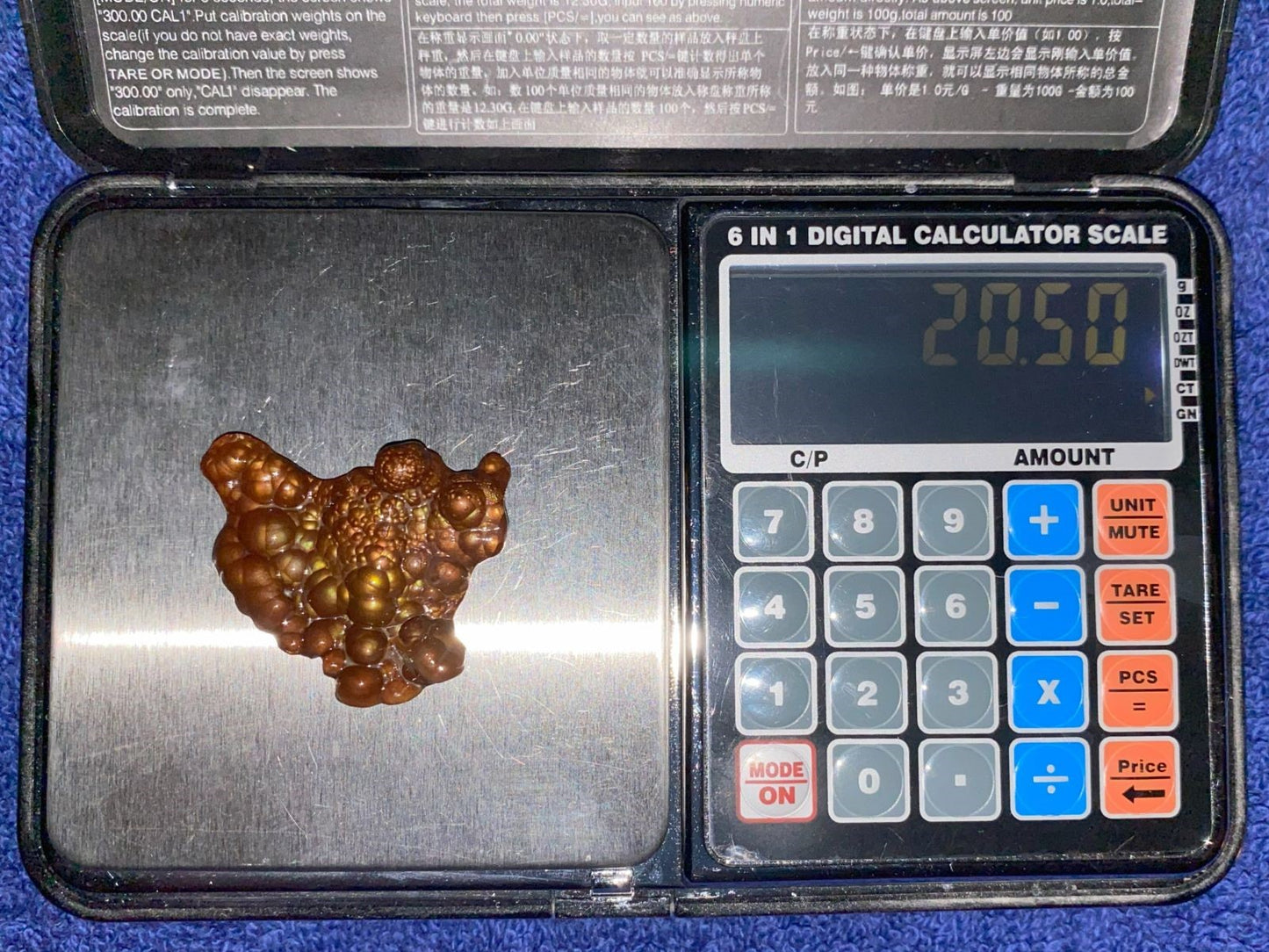 Deer Creek Fire Agate Gemstone Mineral Specimen on a digital calculator scale with visible weight reading
