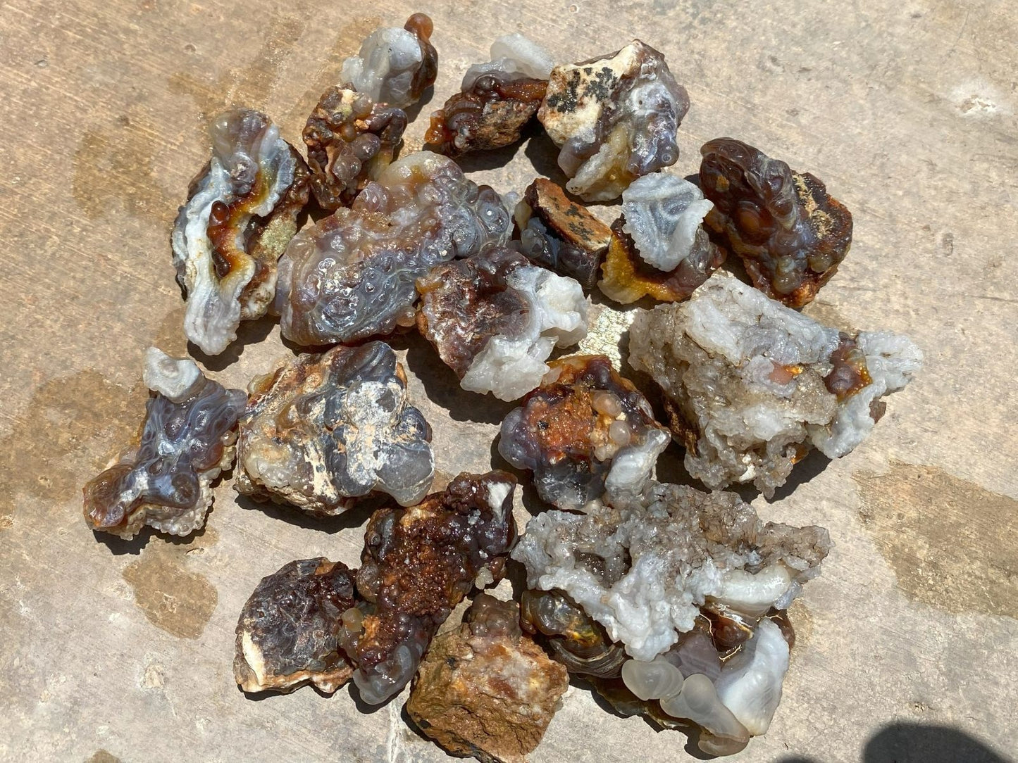 Collection of rough fire agate stones and crystals on a textured surface