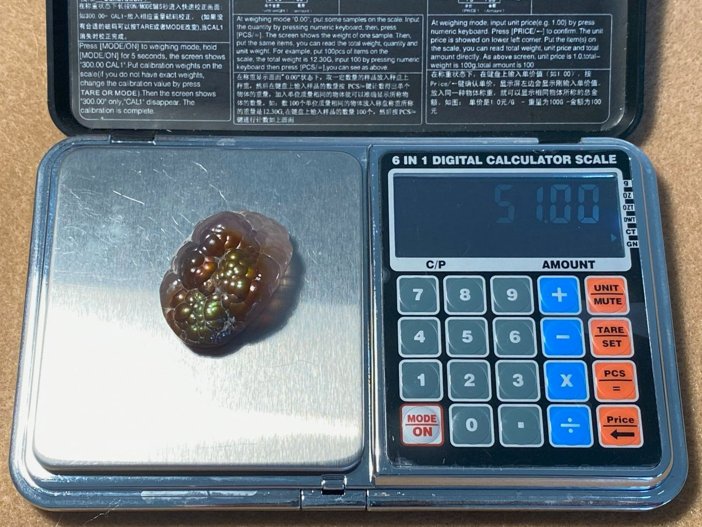 Small gemstone on a digital calculator scale with a visible display of weight.