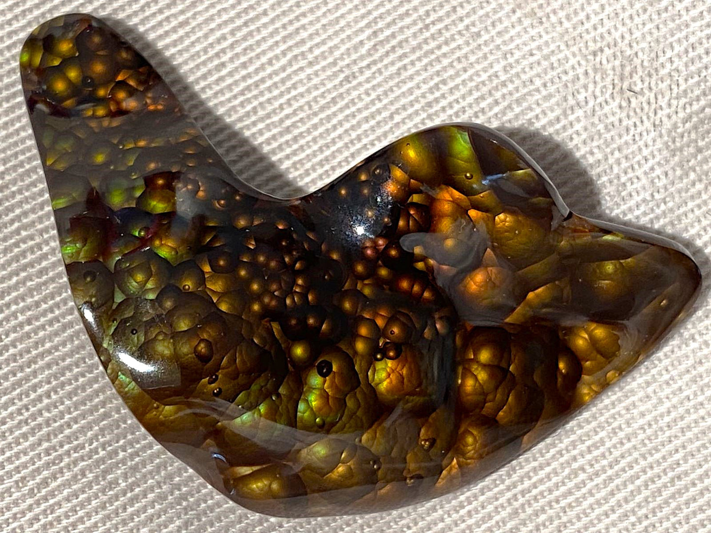 Decorative loose gemstone with a wavy pattern on a textured white background