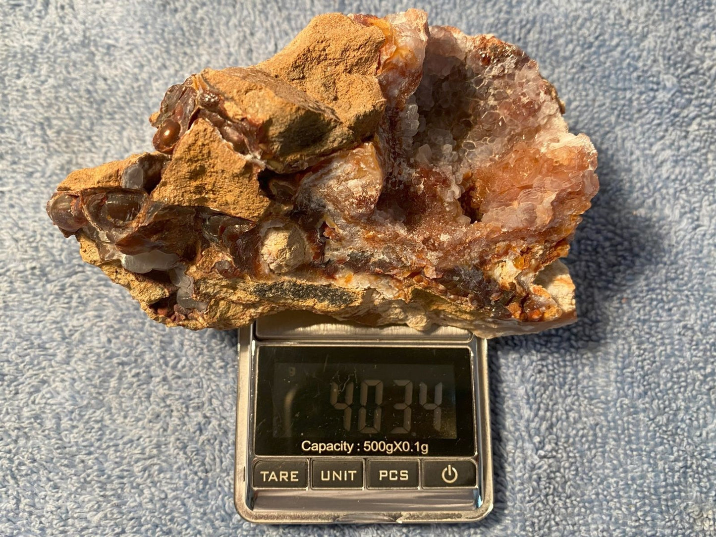 Slaughter Mountain fire agate rough mineral specimen sample on a digital scale with a gray background