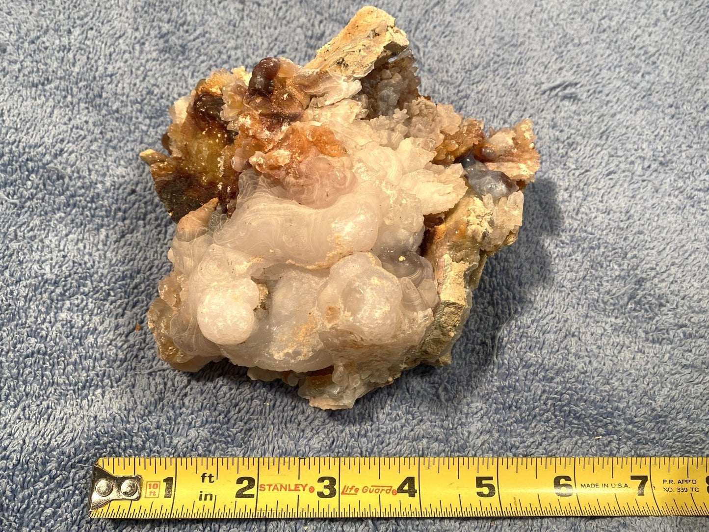 Mineral sample with a measuring tape at the bottom on a blue background