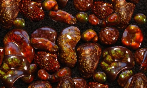 Close-up of fire agate gemstones with various shades of brown and green.