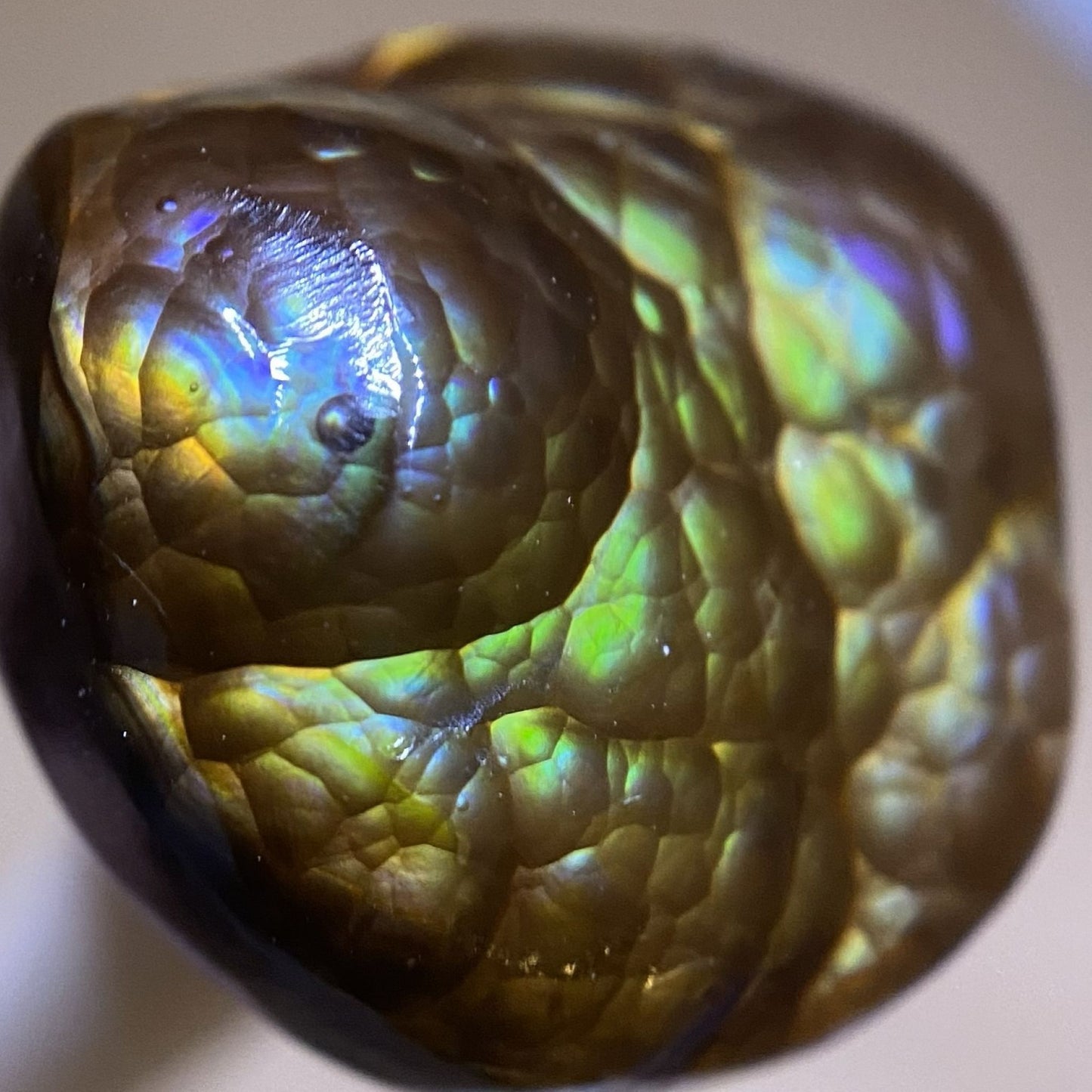 Close-up of a colorful Deer Creek fire agate gemstone with iridescent blue and green properties