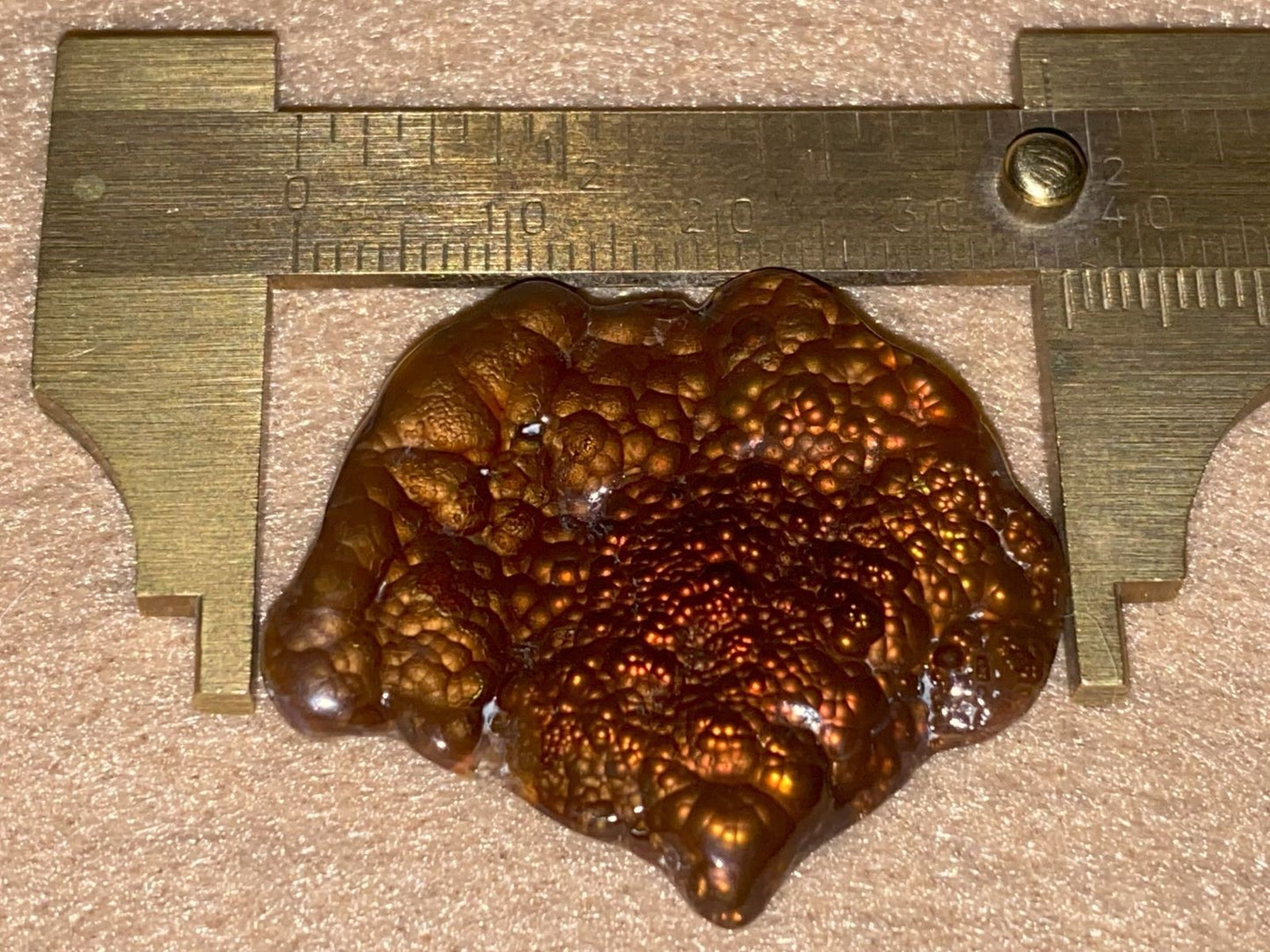 Fire Agate Gemstone on a ruler for scale