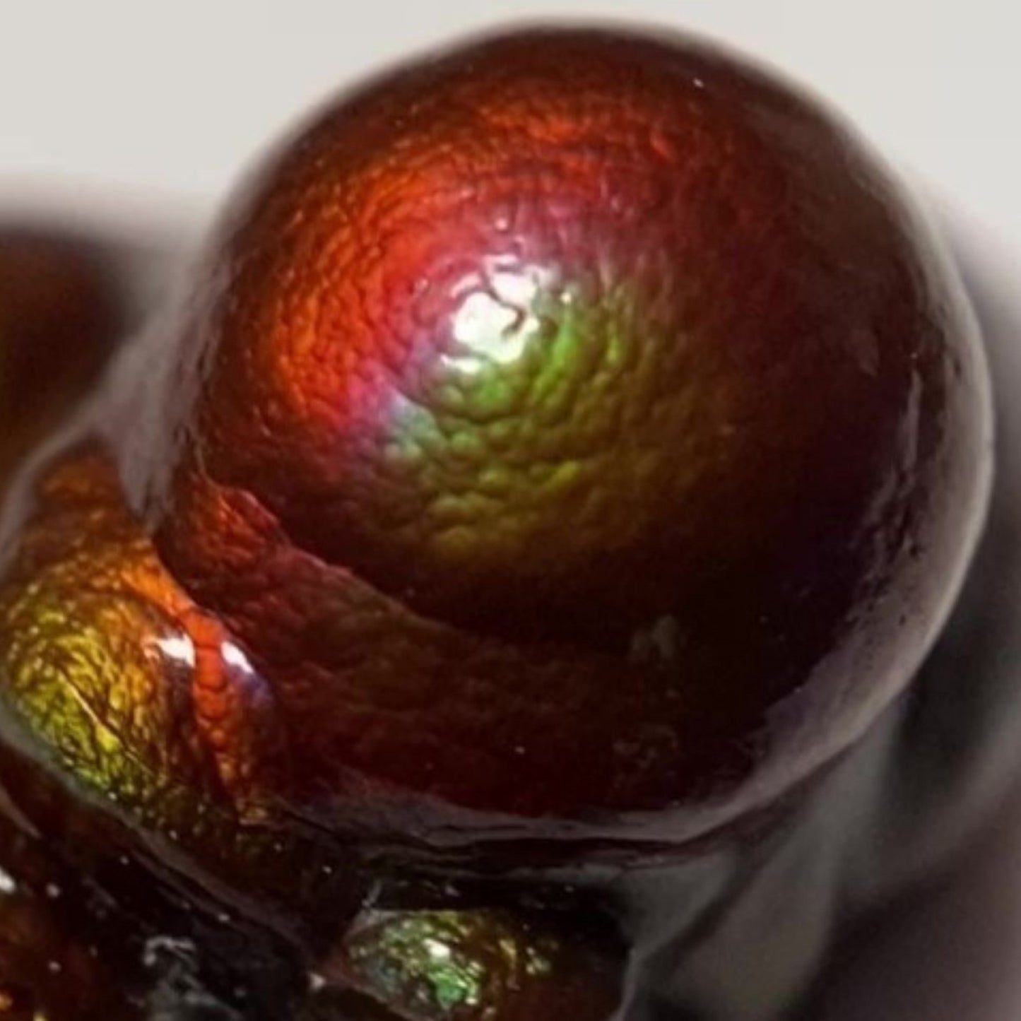 Close-up of a metallic, multicolored colorful Deer Creek Fire Agate Nodule Gemstone Mineral Specimen with a glossy surface.