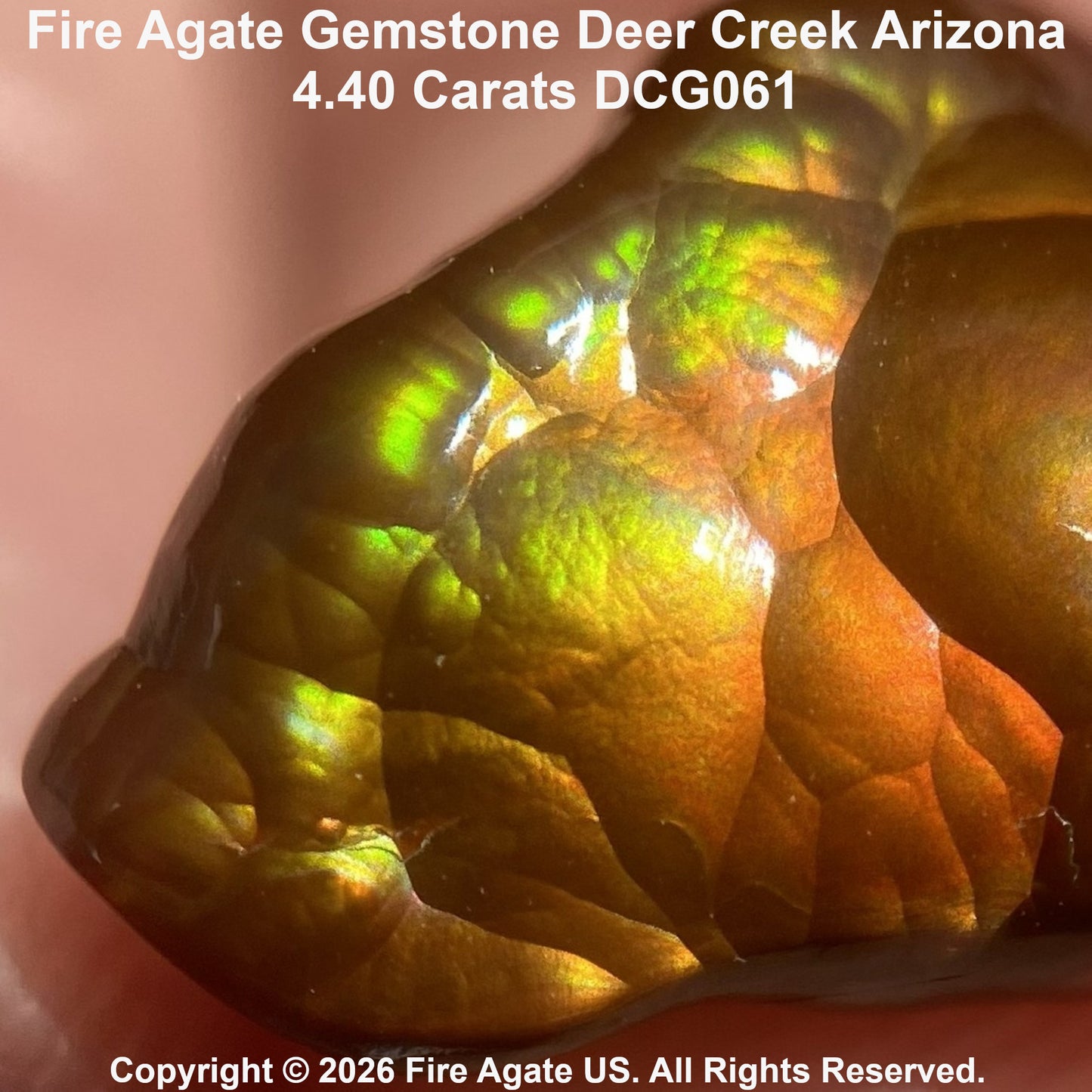 Close-up of a polished fire agate gemstone with iridescent green, yellow, and orange play-of-color on a warm brown base, with text identifying Deer Creek Arizona and a 4.40 carat size.
