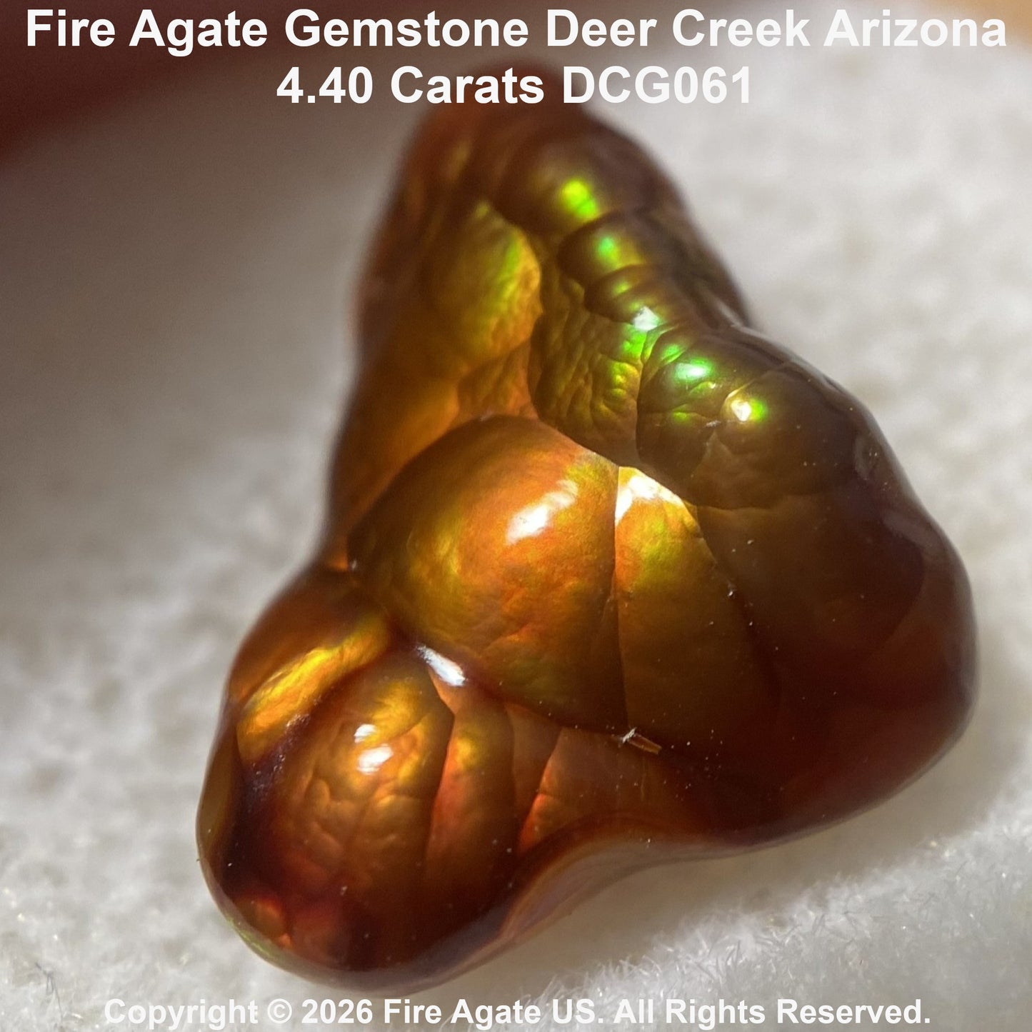 A 4.40 carat Fire Agate gemstone with a rich amber-brown body and vibrant green, yellow, and orange iridescent flashes, displayed on a textured white background with product details text overlay.