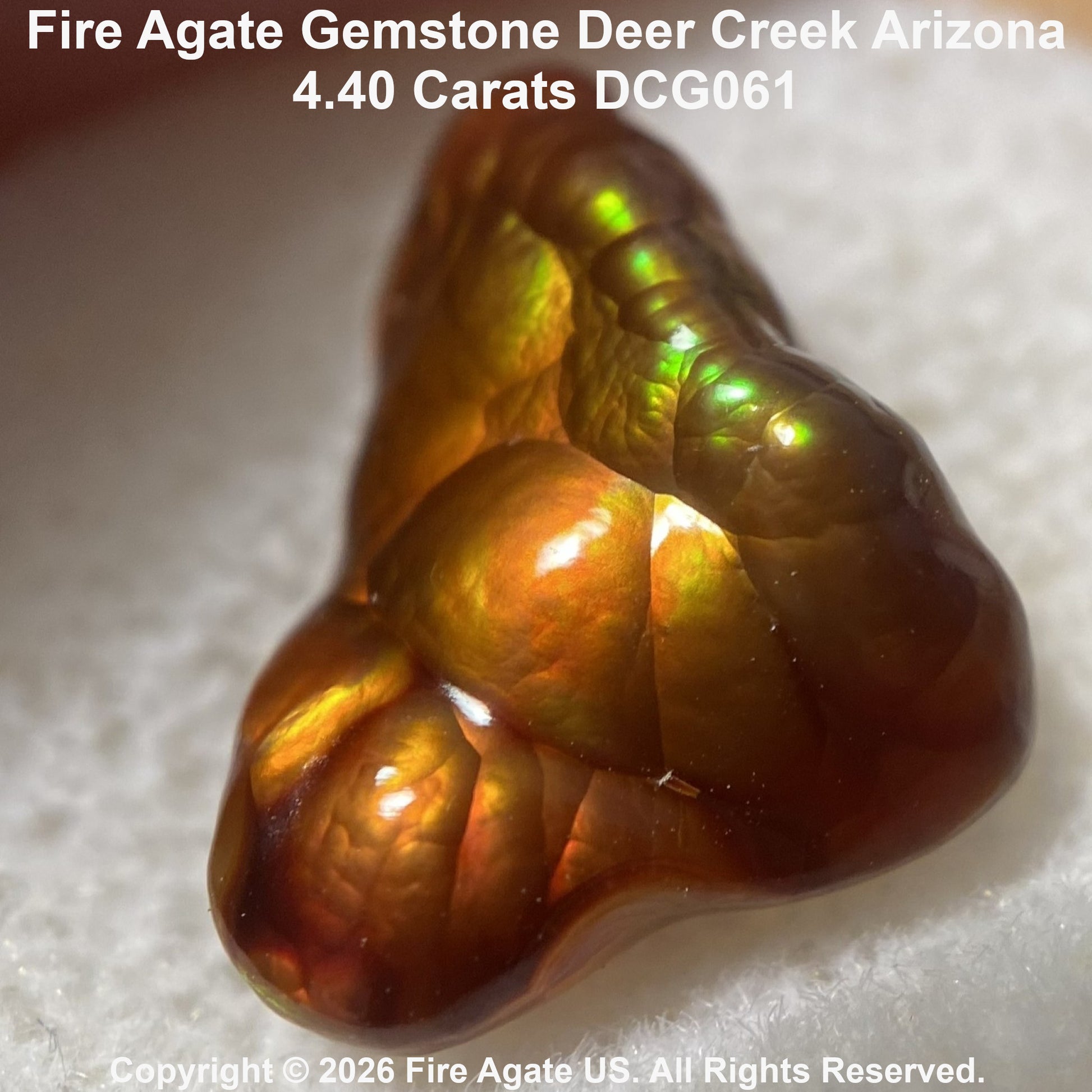 A 4.40 carat Fire Agate gemstone with a rich amber-brown body and vibrant green, yellow, and orange iridescent flashes, displayed on a textured white background with product details text overlay.