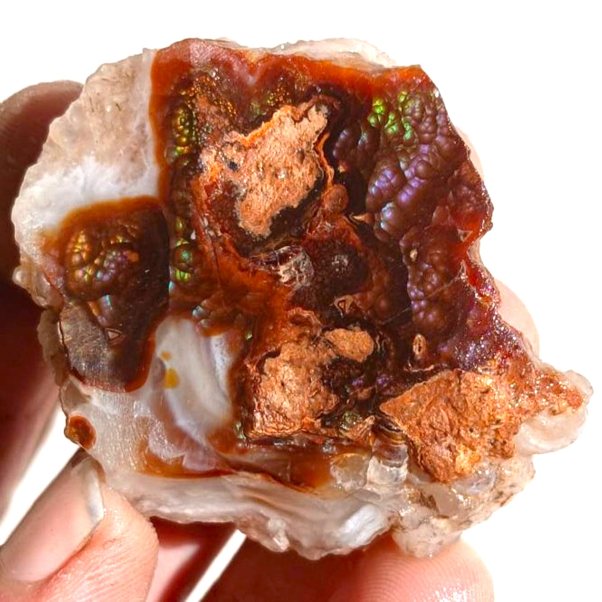 Close-up of a windowed Deer Creek fire agate rough mineral display specimen with embedded mineral deposits held by a hand.