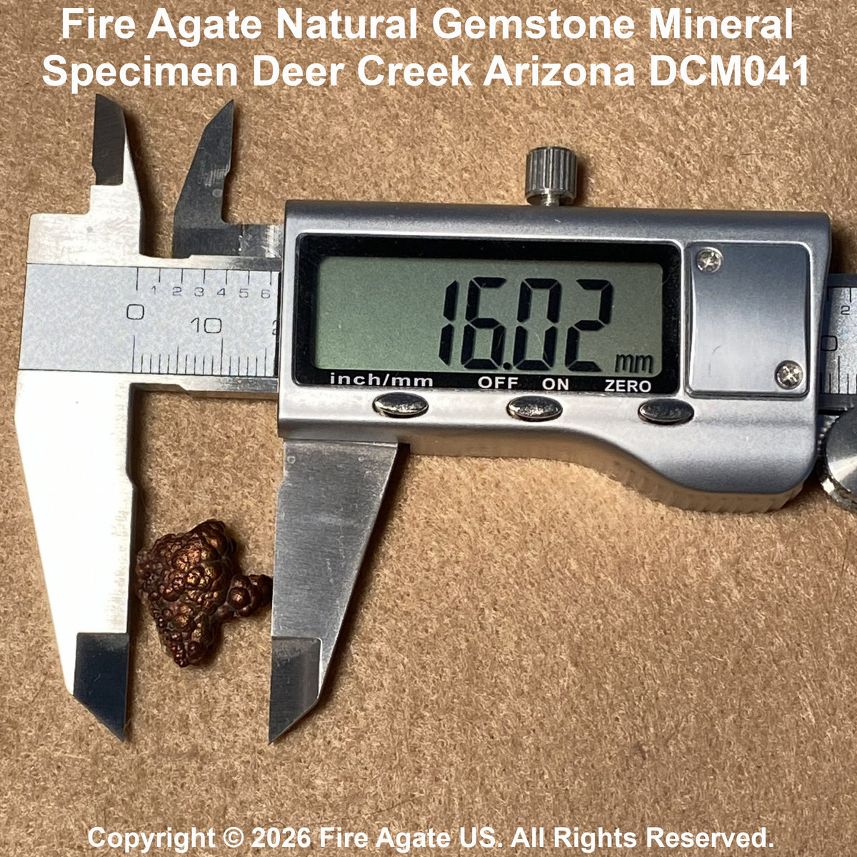 A small brown fire agate gemstone specimen placed under a digital caliper showing a measurement of 16.02 mm, on a textured tan background with text identifying the specimen as Deer Creek Arizona DCM041.
