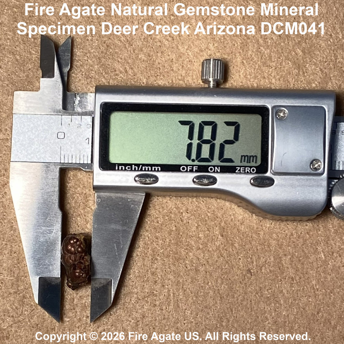 A small brown fire agate gemstone mineral specimen measured with a digital caliper showing 7.82 mm.