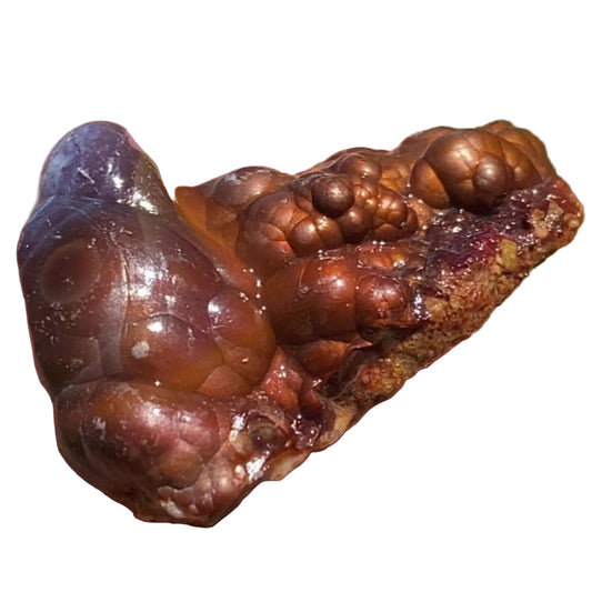 Close-up of a brownish-red Deer Creek fire agate mineral stone on a white background