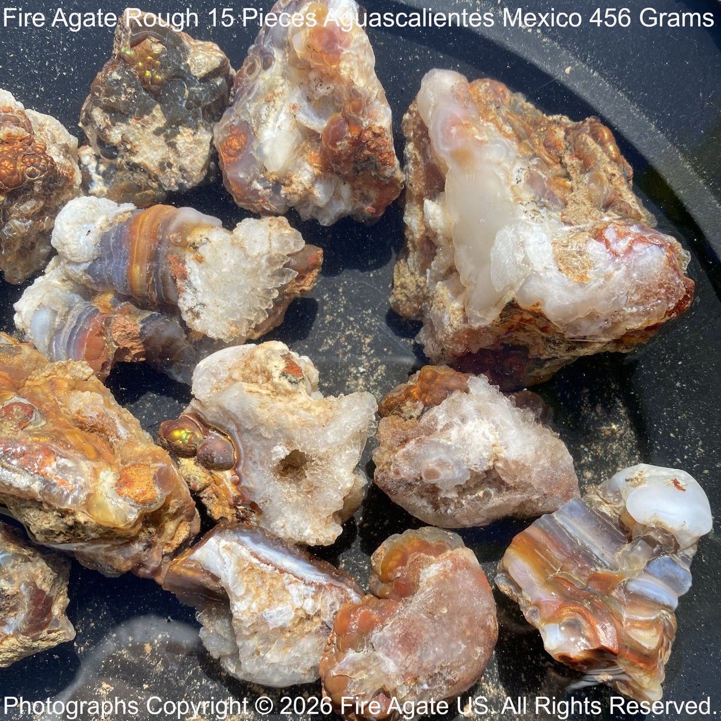 Fire Agate Rough pieces from Aguascalientes, Mexico on a black surface.