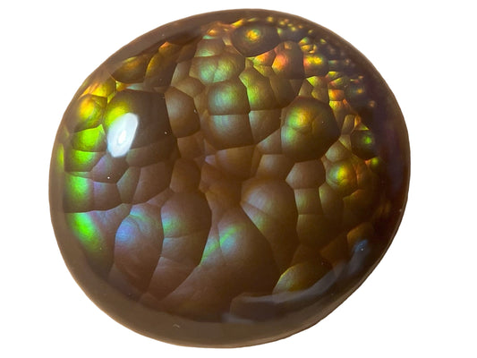 Round, iridescent Aguascalientes Fire Agate Gemstone with a multicolored pattern on a white background