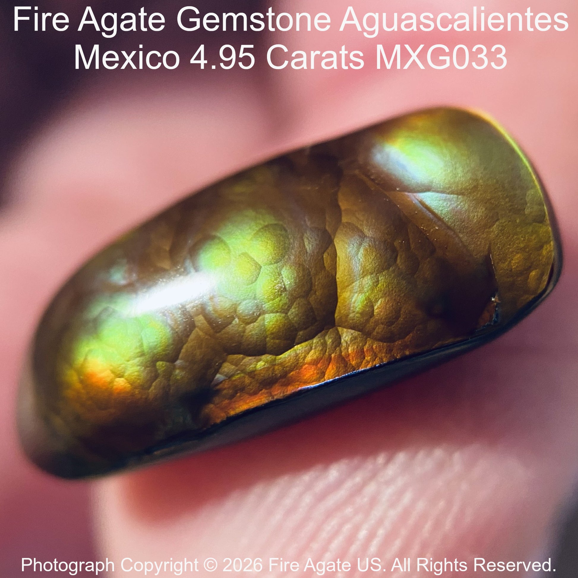 A close-up of a polished Fire Agate gemstone held against a finger, showing its iridescent color-shifting surface with green, gold, and orange tones. Text at the top reads 'Fire Agate Gemstone Aguascalientes Mexico'.
