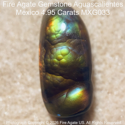 A 4.95 carat Fire Agate gemstone with a dark brown base and vibrant green, yellow, and blue iridescent flashes, shown on a textured beige background with product details text overlay.