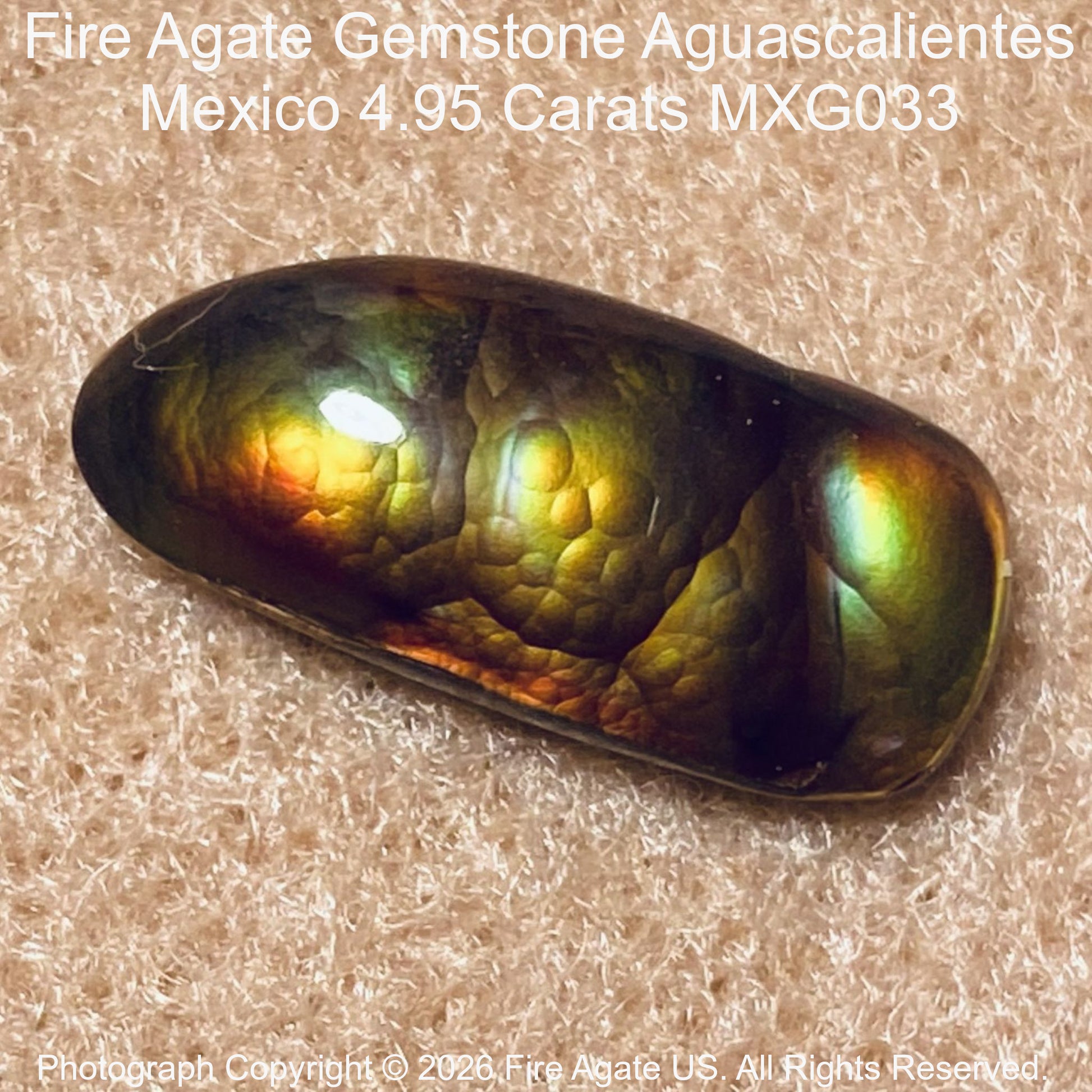 A polished Fire Agate gemstone with a rounded teardrop shape, displaying a vibrant iridescent play-of-color with green, gold, orange, and blue hues on a textured beige background. Text overlays identify the gemstone as 'Fire Agate Gemstone Aguascalientes Mexico'.