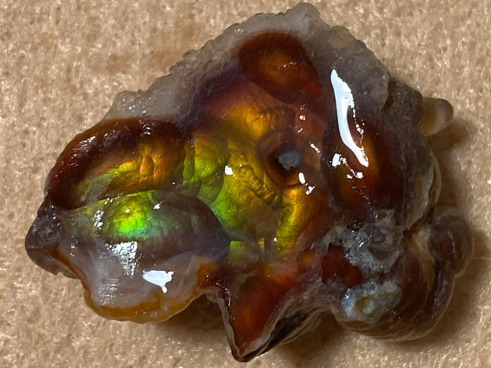 Iridescent crystal on a beige background
