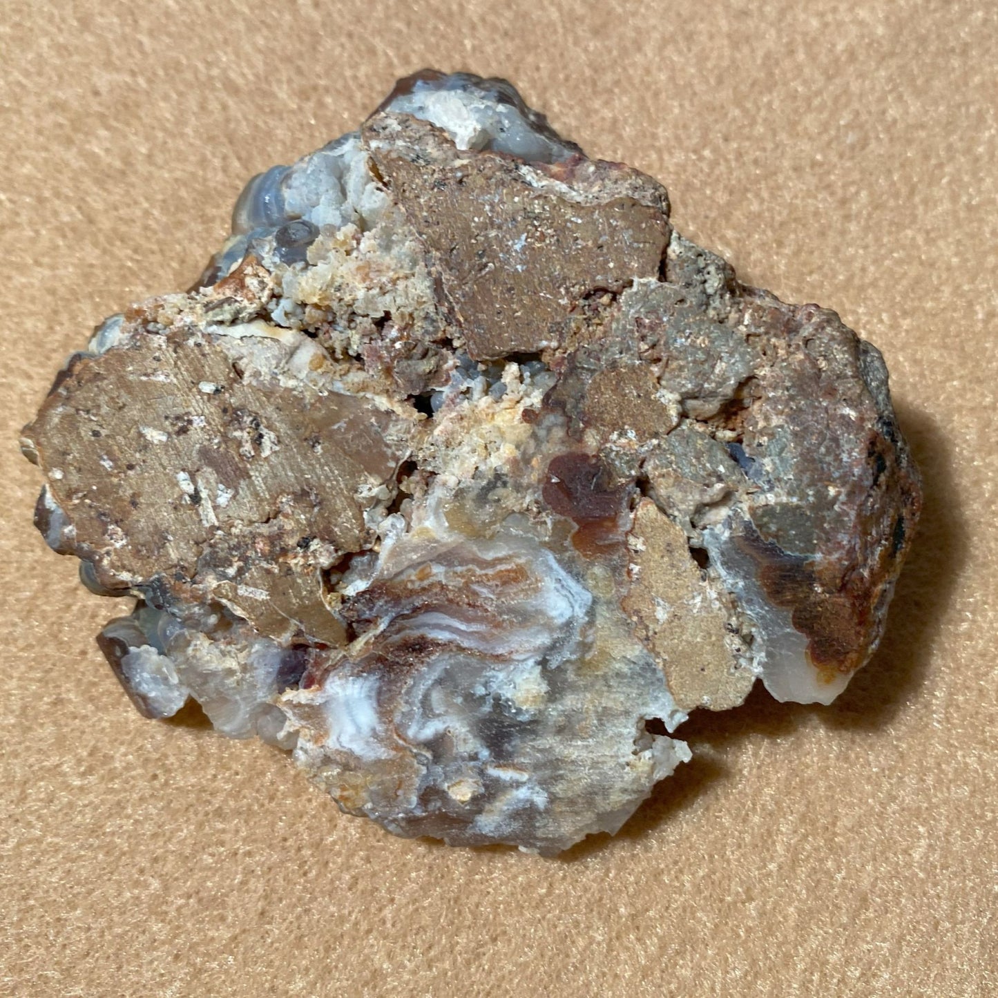 Aguascalientes Fire Agate Rough Mineral sample on a beige background