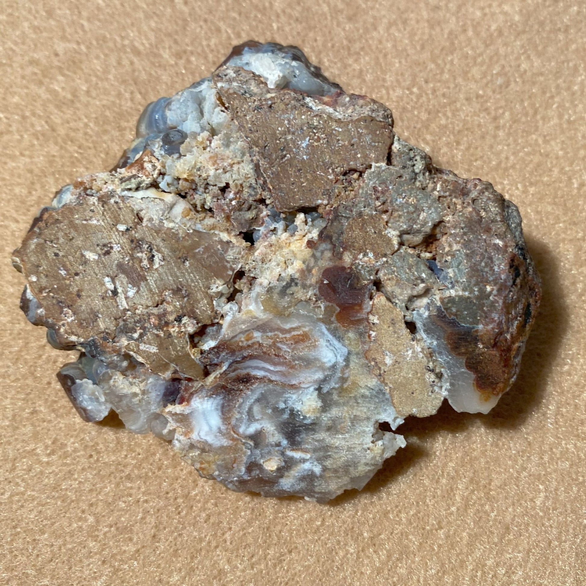 Aguascalientes Fire Agate Rough Mineral sample on a beige background