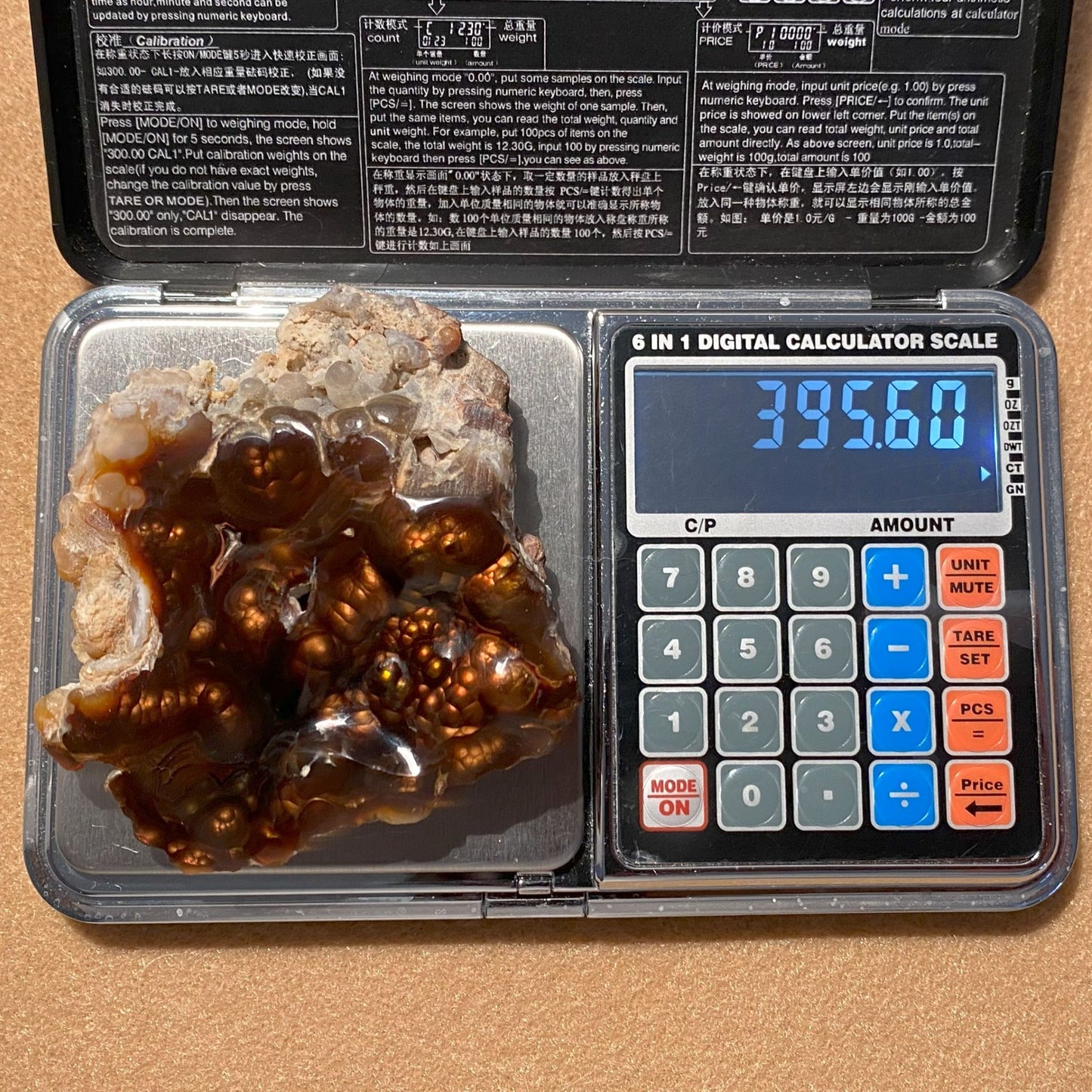 Digital calculator scale with a Aguascalientes Fire Agate on a brown background
