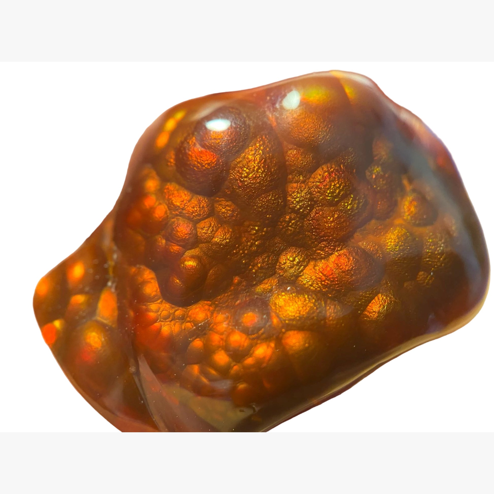 lose-up of a large polished Slaughter Mountain fire agate gemstone stone with a neutral white background.