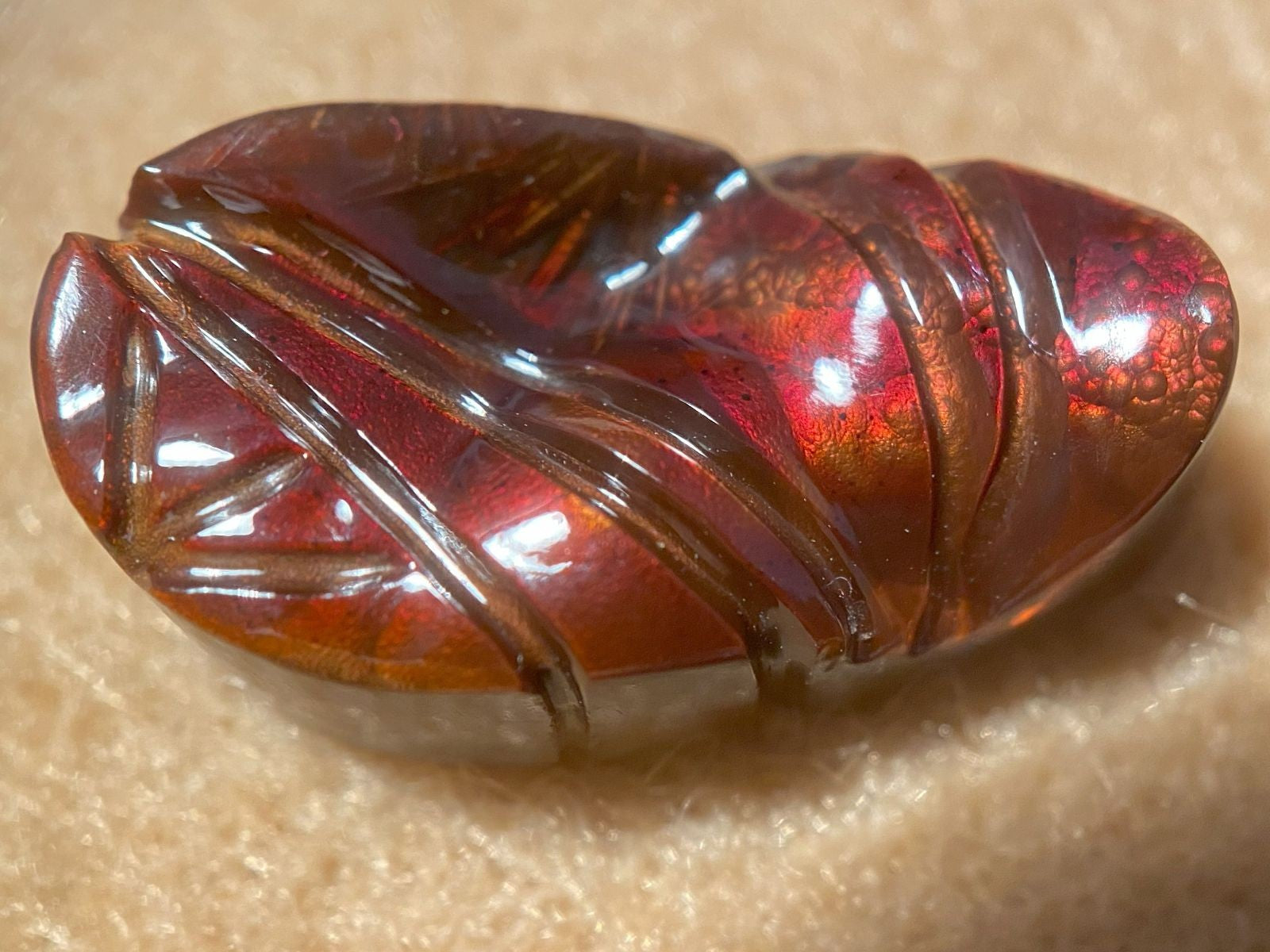 Decorative red and brown fire agate gemstone on a beige background