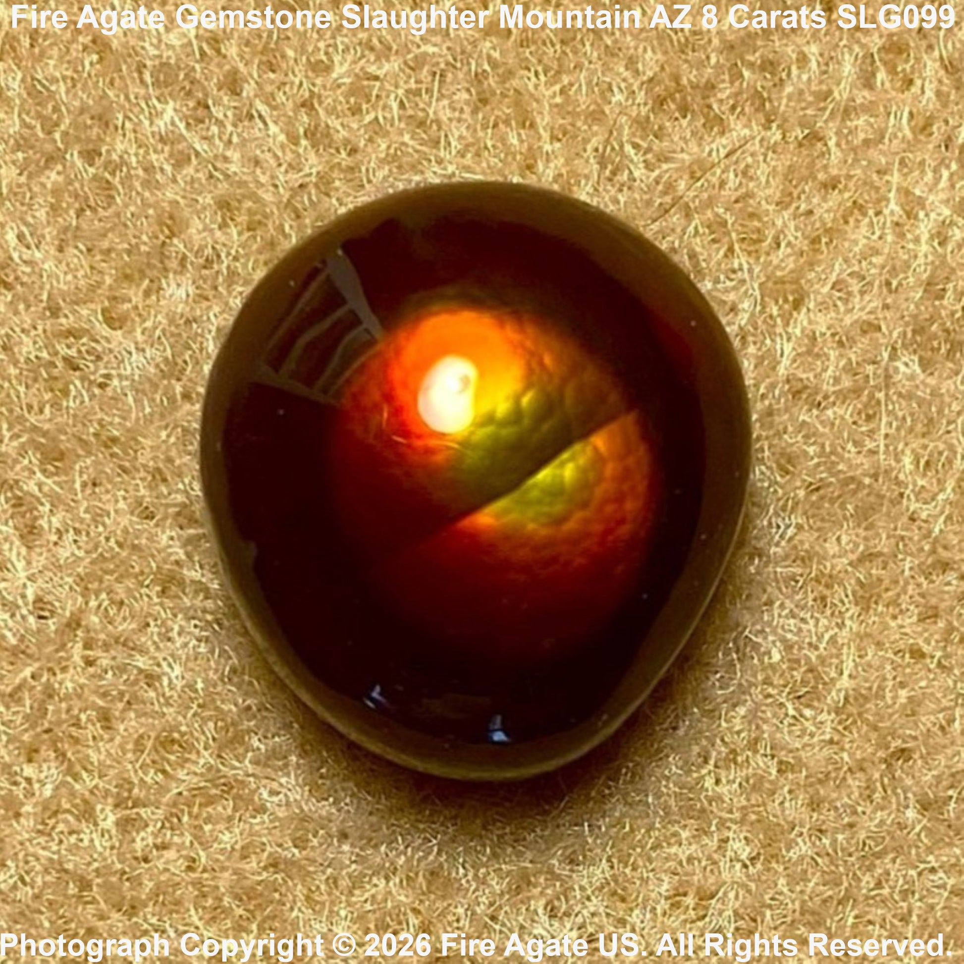 A polished cabochon gemstone showing a fiery red, orange, and yellow internal play-of-color, set against a textured tan background. Text overlays identify the stone as Fire Agate and provide catalog details.