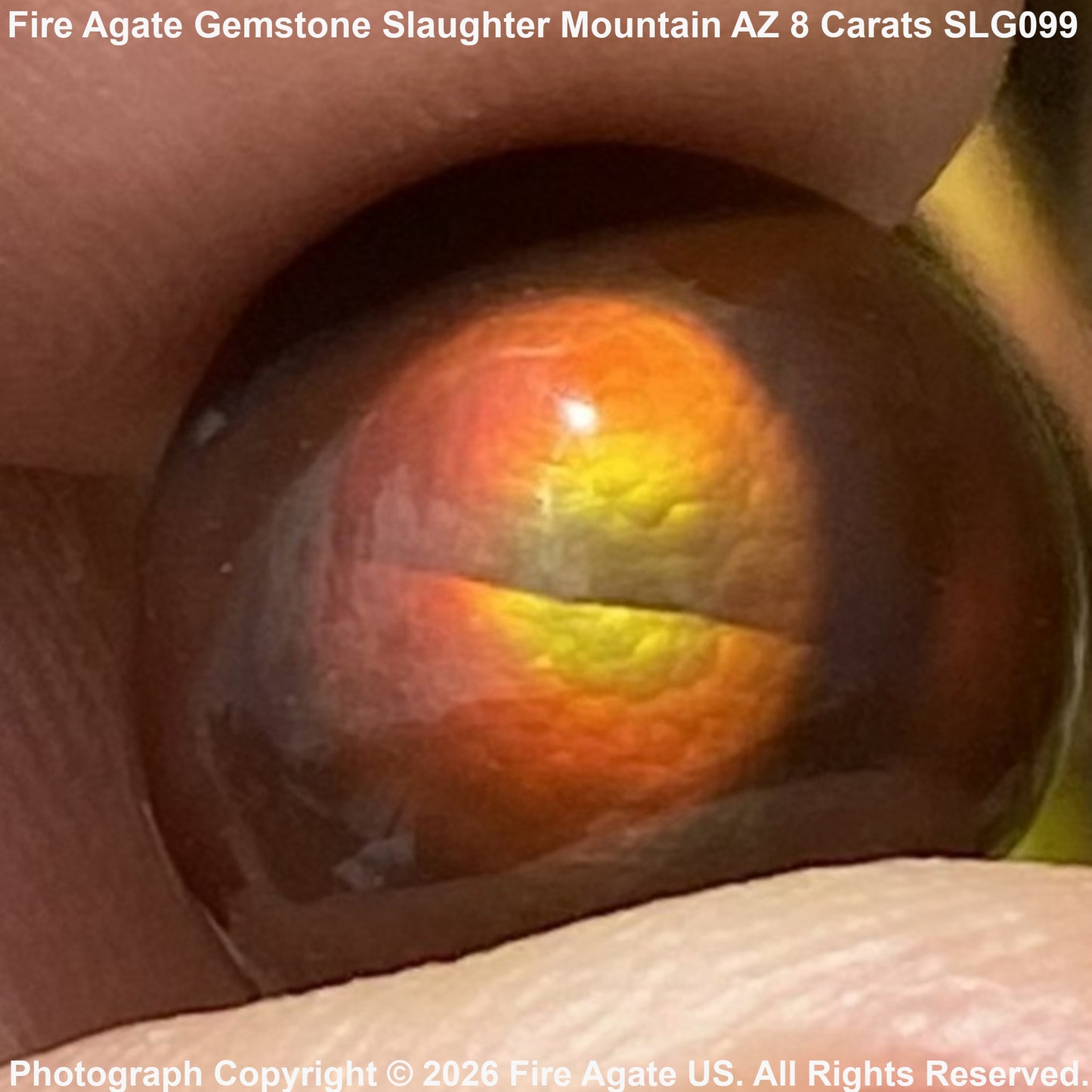 A close-up of a polished fire agate gemstone held between fingers, showing a banded pattern of orange, yellow, and dark brown. Text overlays indicate the variety name 'Slaughter Mountain' and carat weight '8 Carats'.