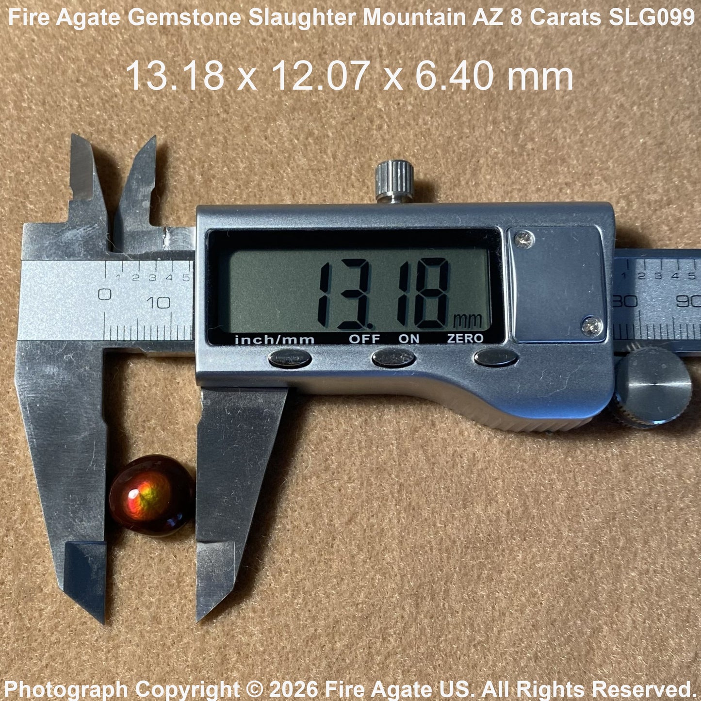 A small round fire agate gemstone with an iridescent red-orange finish is shown under a digital caliper on a tan textured background. White text at the top reads 'Fire Agate Gemstone Slaughter Mountain AZ 8 Carats SLG09' with dimensions '13.
