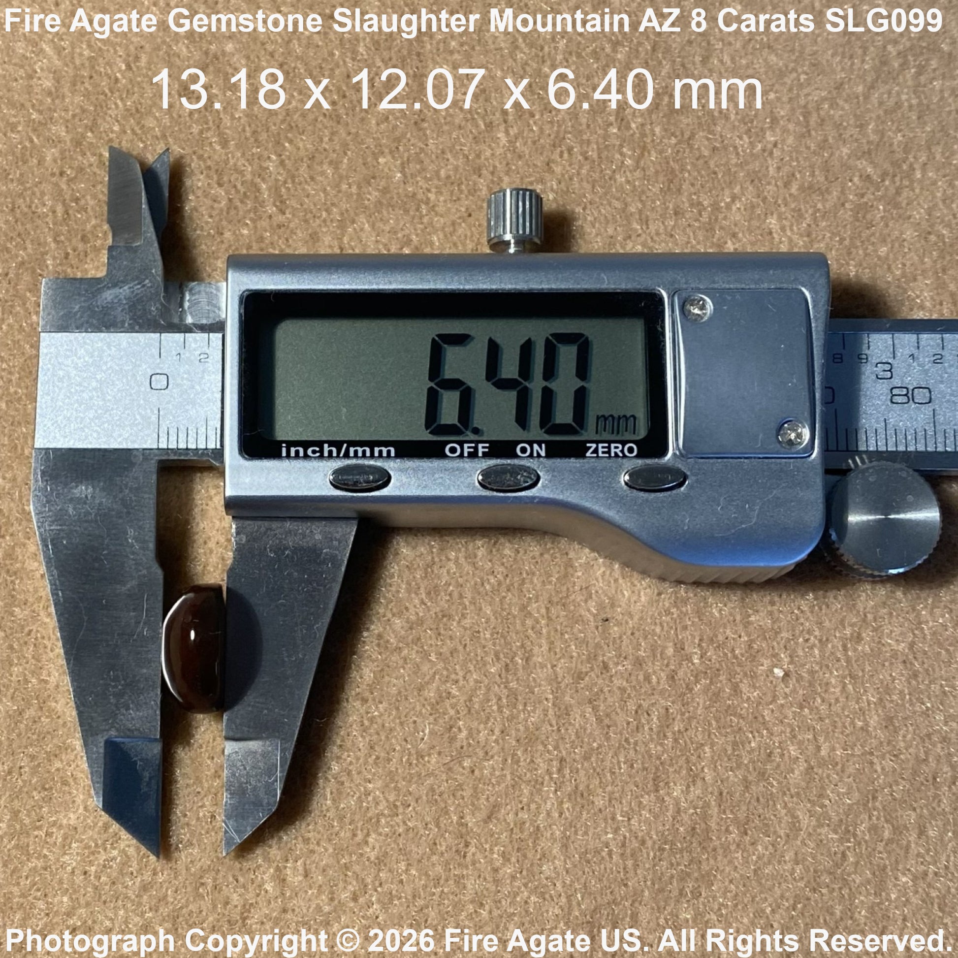 A digital caliper measuring a small oval fire agate gemstone on a brown textured surface, with text overlay showing the gemstone dimensions of 6.40 mm.