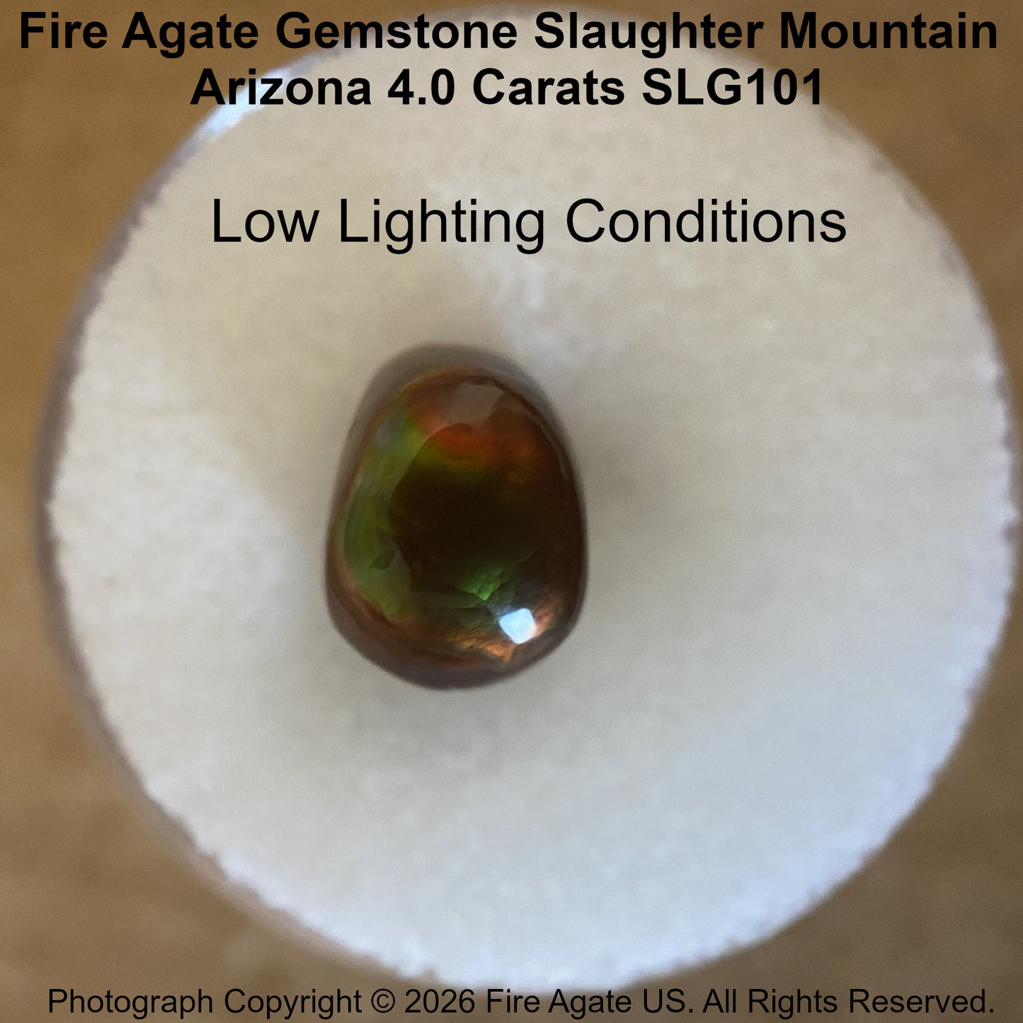 A 4.0 carat fire agate gemstone with a polished, teardrop-shaped form, displayed on a white circular cushion.