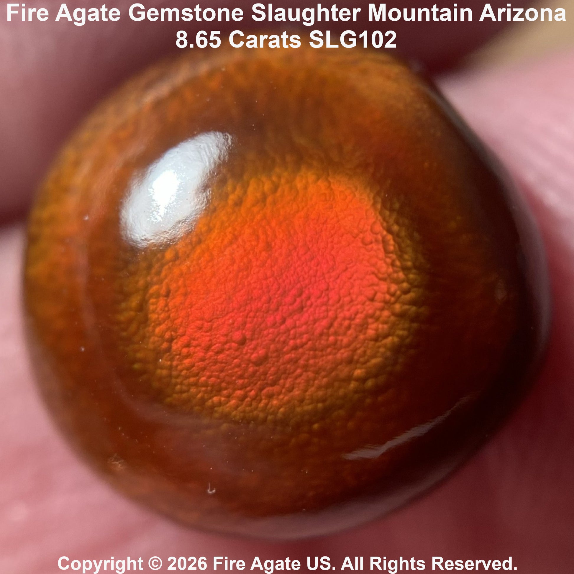 A close-up of a polished fire agate gemstone held against a person's fingers, showing a vibrant orange and red fiery pattern on a brown translucent background. Text overlays identify the stone as 'Fire Agate Gemstone Slaughter Mountain Arizona'.