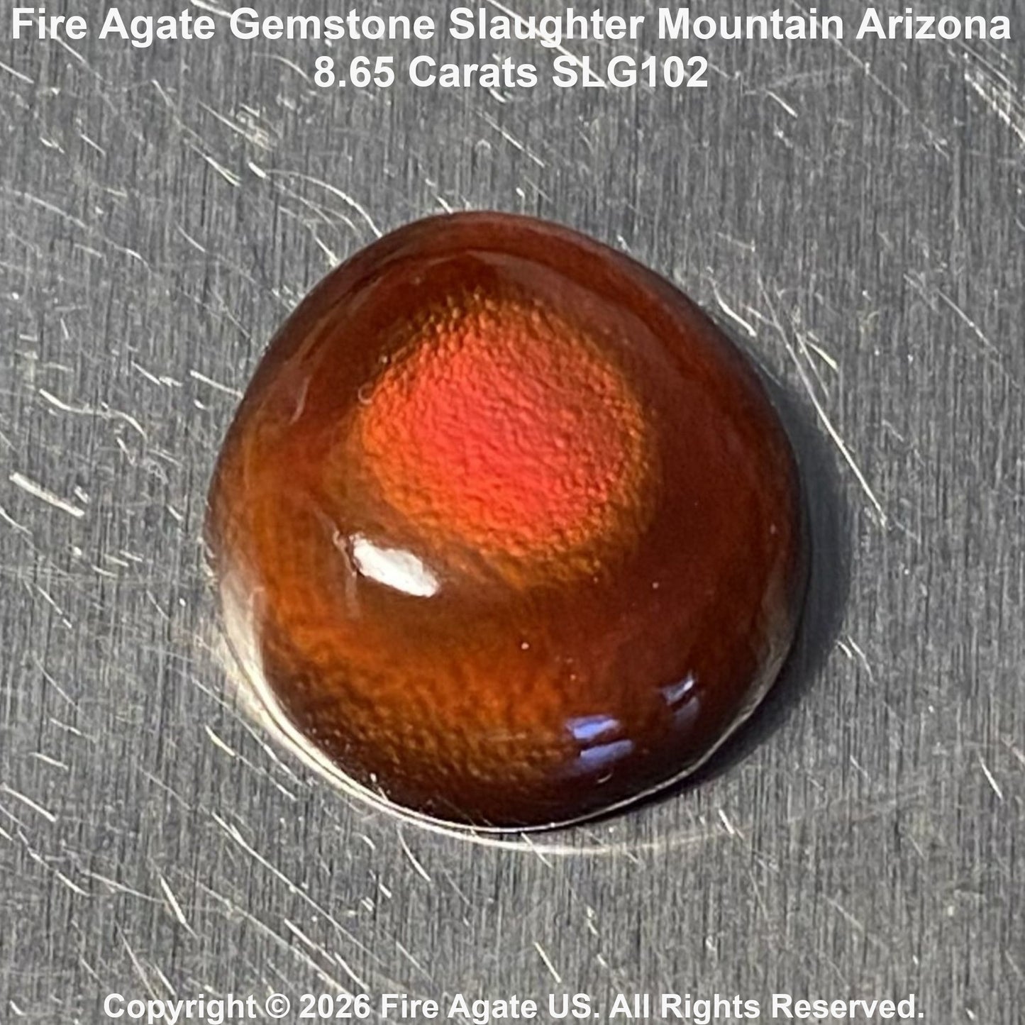 A 8.65 carat fire agate gemstone with a vibrant orange-red center and dark brown outer edges, displayed on a brushed metal surface with text overlays.