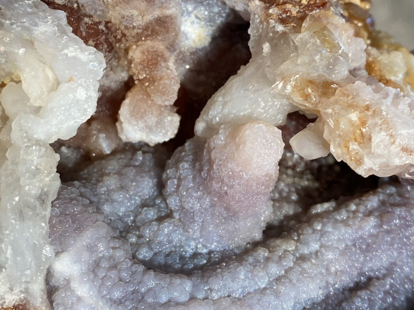 Close-up of a crystal formation within a Slaughter Mountain Fire Agate Mineral Specimen showing various shades of white and beige.