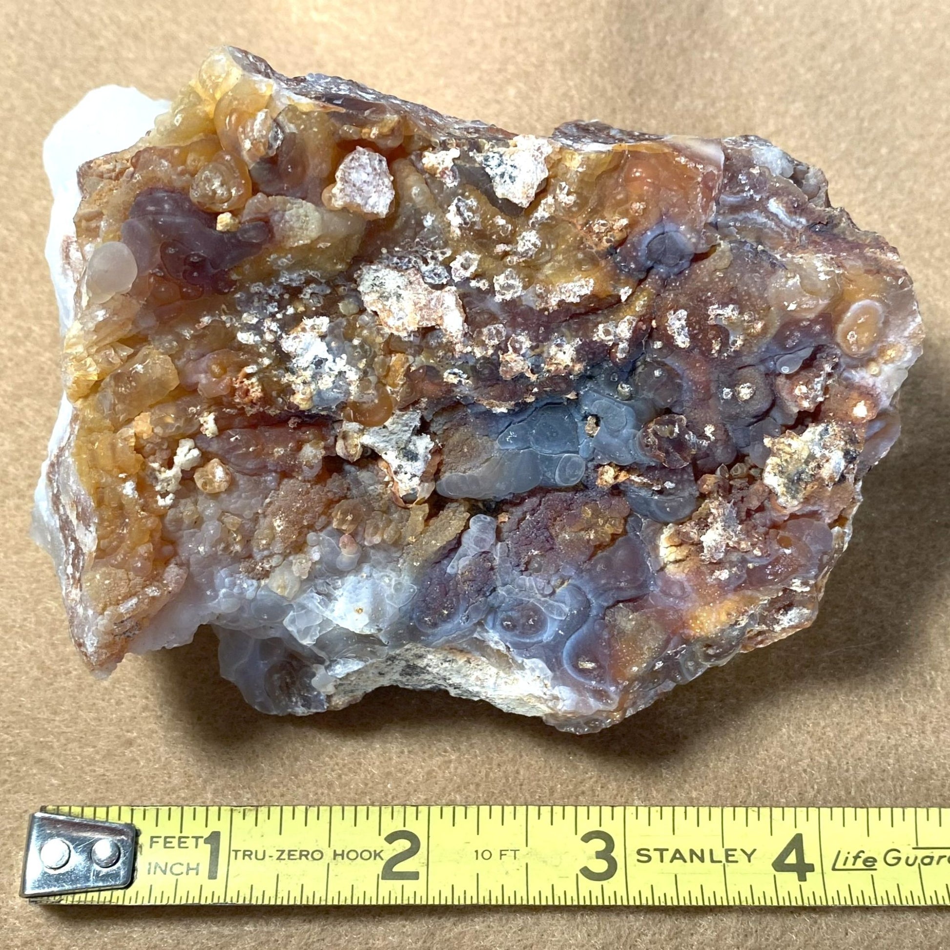 Mineral sample with a measuring tape for scale on a brown background