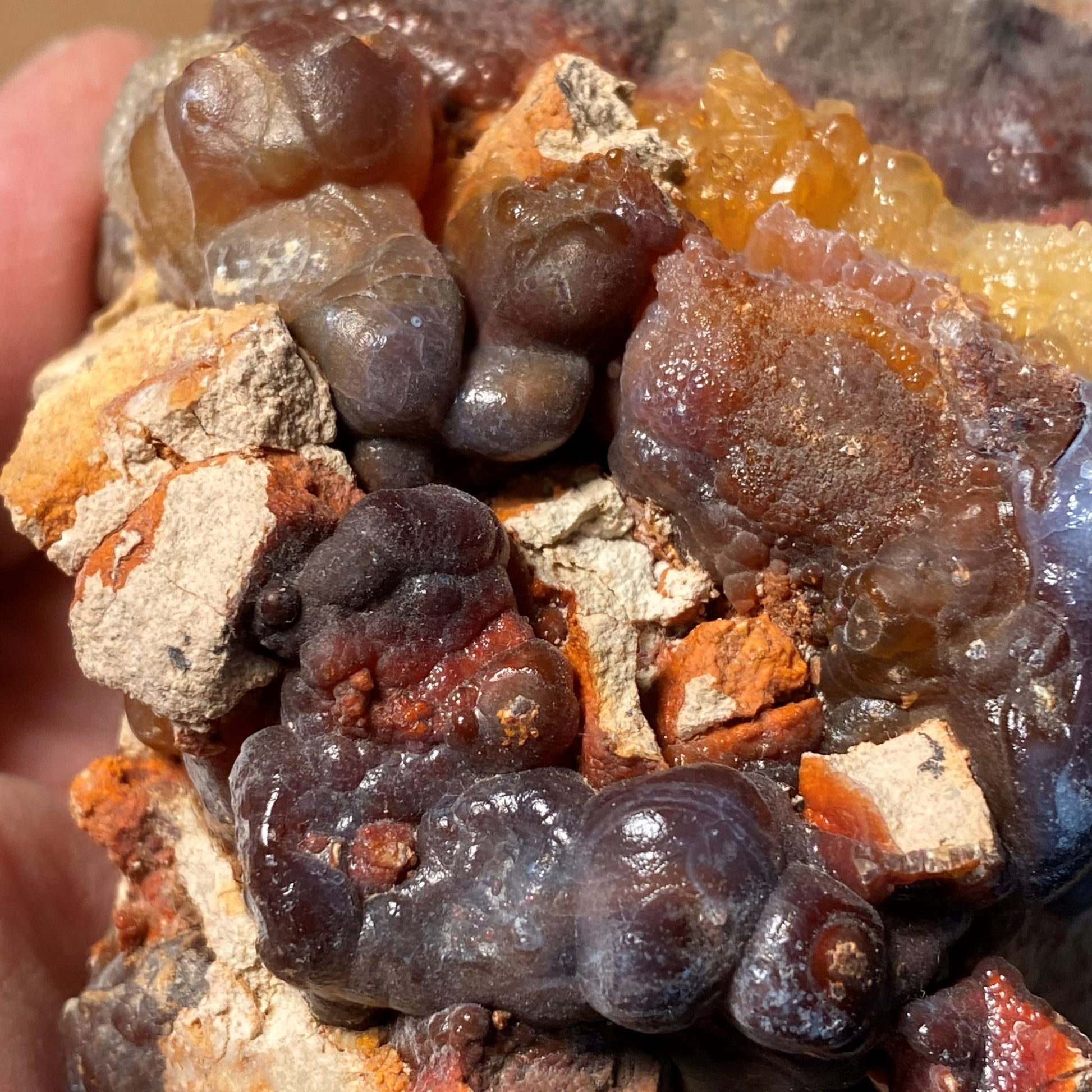 Close-up of a fire agate rough crystal mineral sample with various colors and textures.