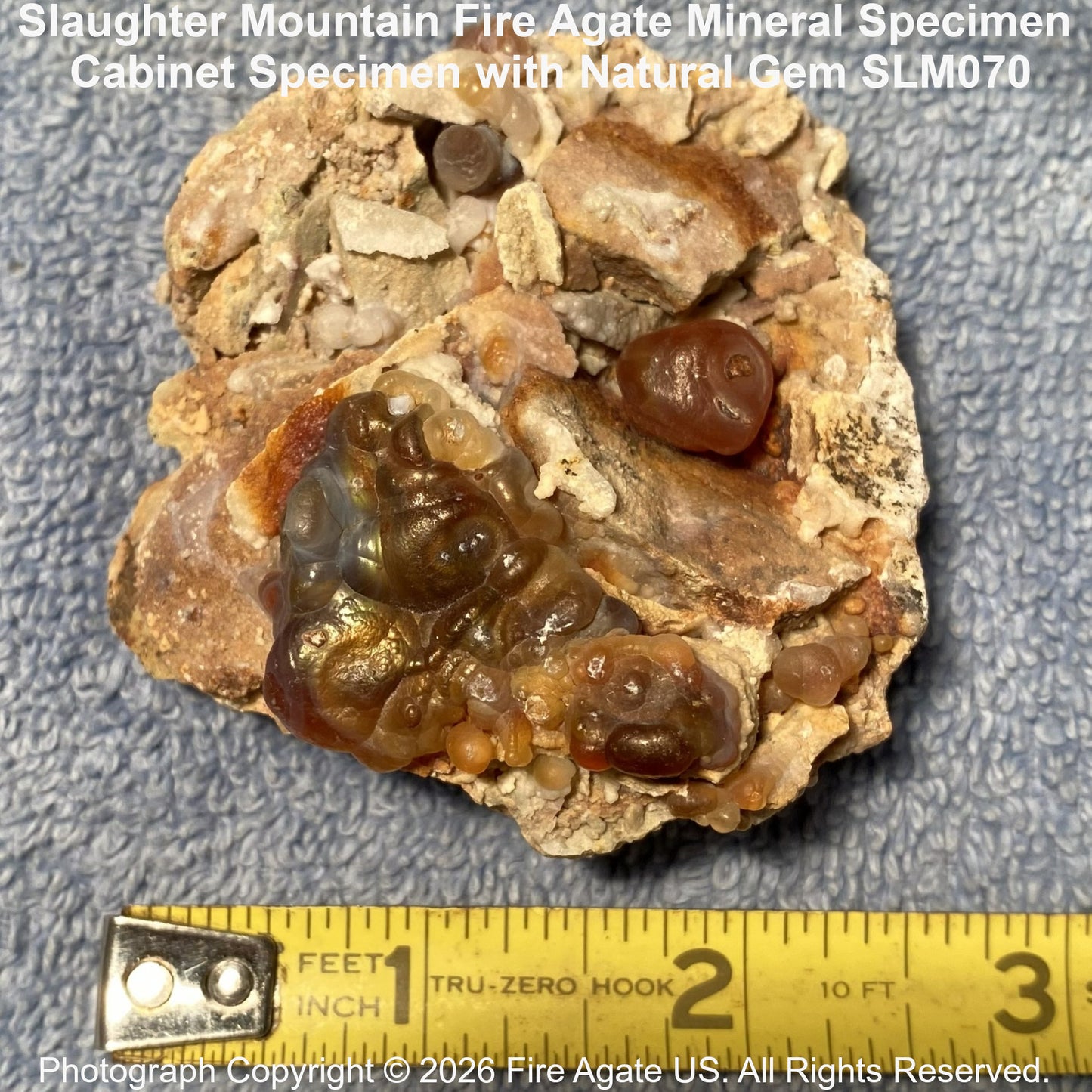 Fire agate mineral specimen shown with ruler for scale