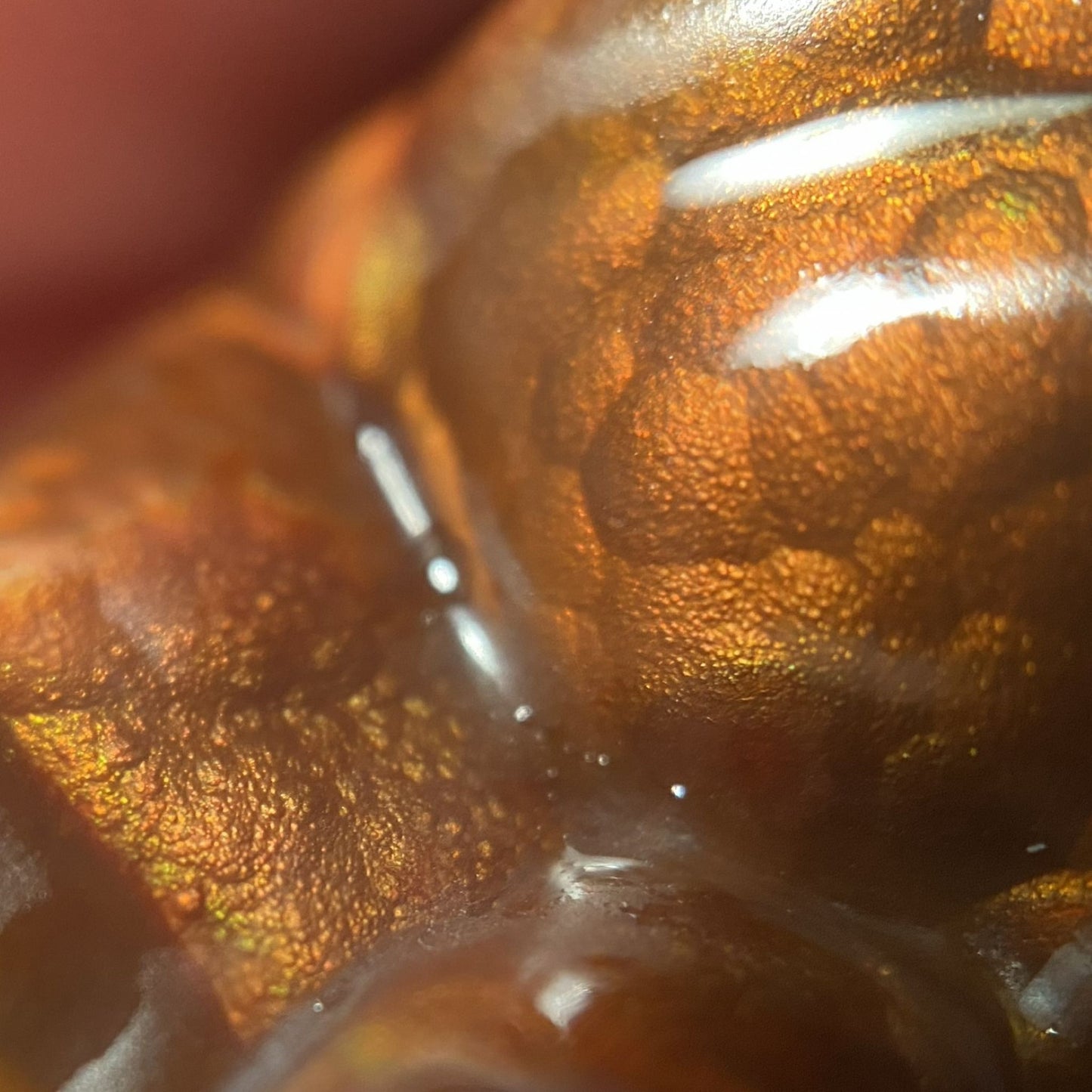 Close-up of a textured Slaughter Mountain preform fire agate gemstone with a hand holding it