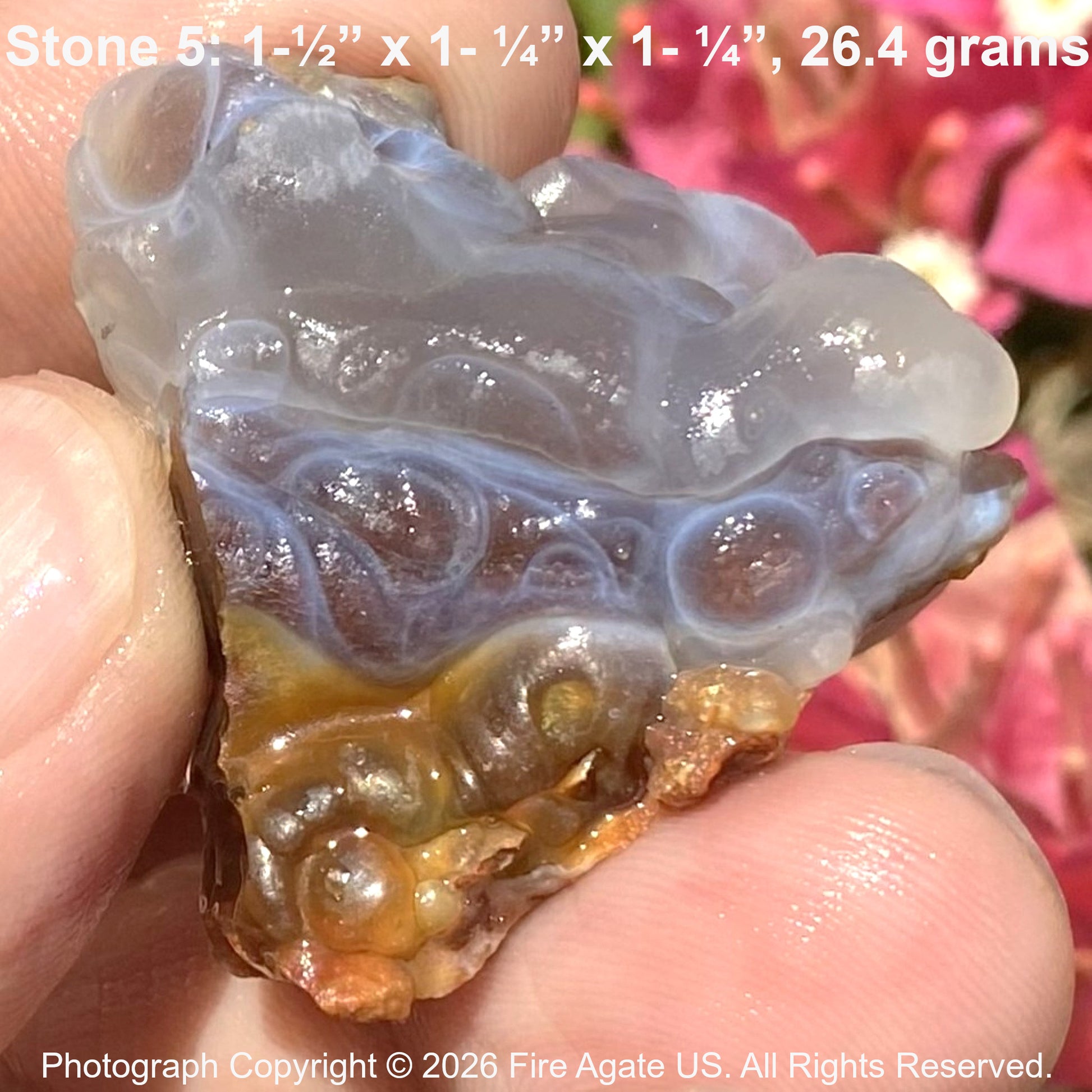 Close-up of a fire agate stone held between fingers with text overlay.